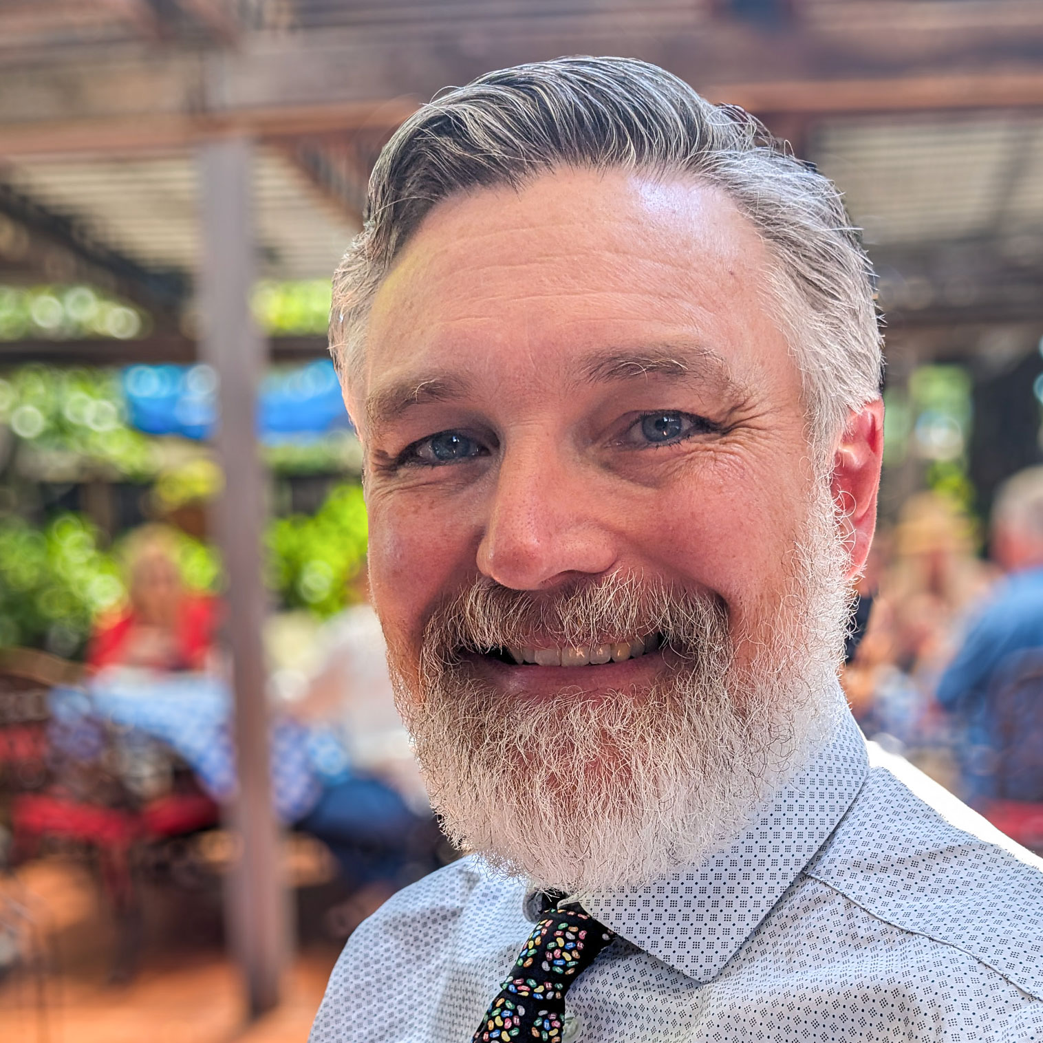 Smiling man with gray beard outdoors
