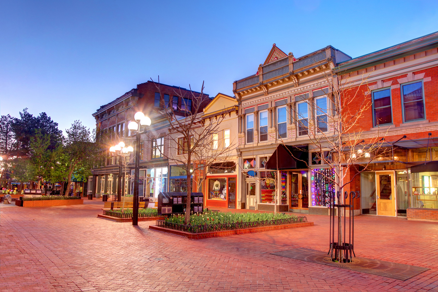Historic downtown street with colorful storefronts at dusk in Boulder, Colorado.
