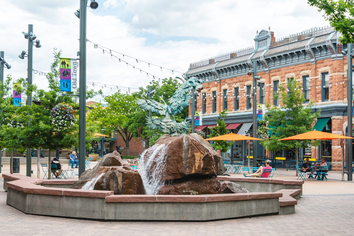 Fort Collins, downtown sculpture fountain with seating and historic architecture.