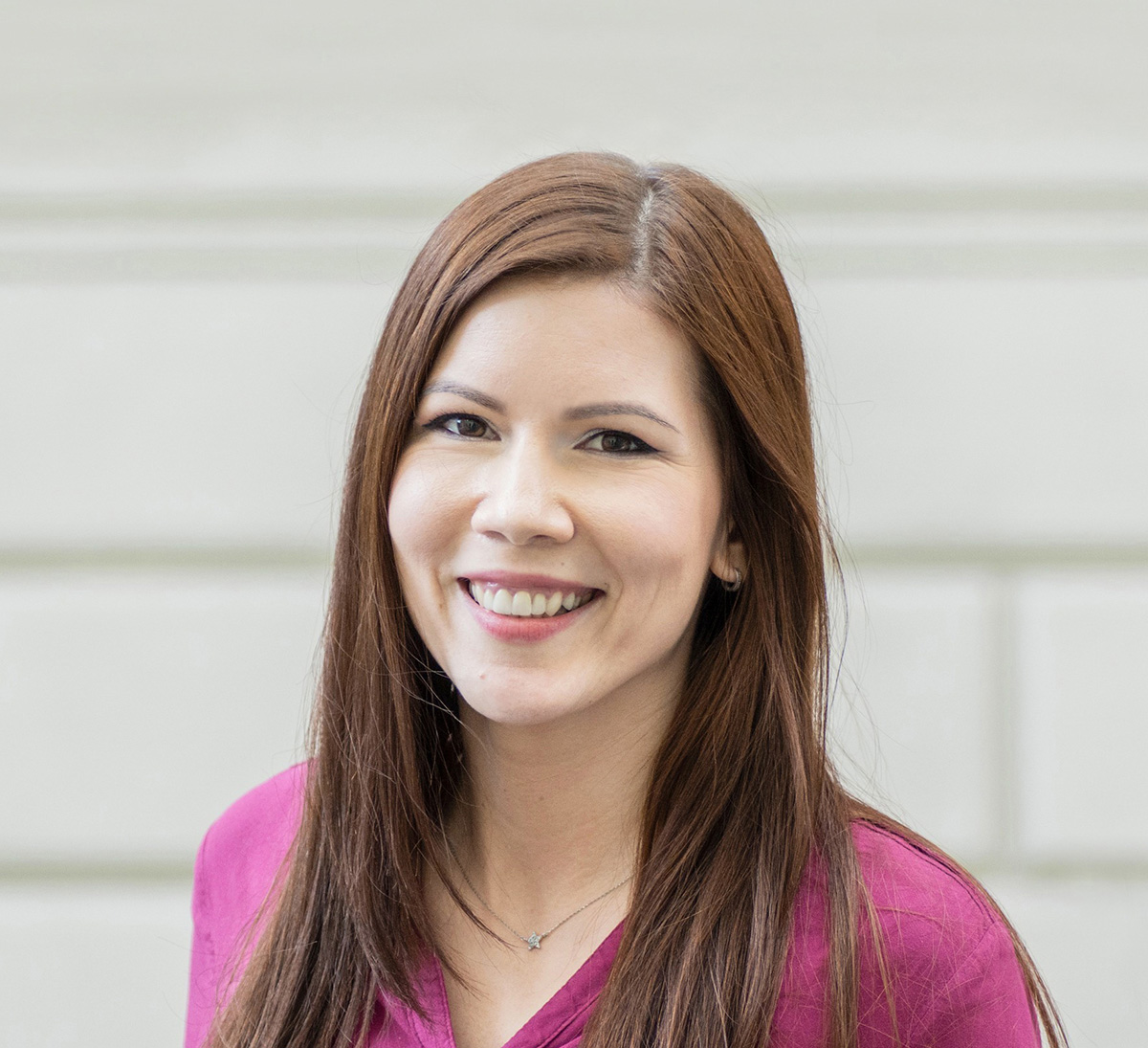 Woman smiling in a pink shirt